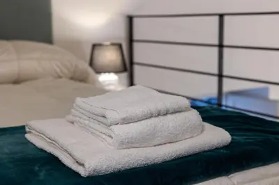 a pile of towels sitting on top of a bed at Maison Castro Casetta a Palermo in Palermo