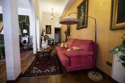 a living room with a red couch and a lamp at Palazzo Viola Suite Panoramica Palermo in Palermo