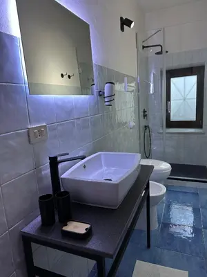 a bathroom with a sink and a toilet at Massimo Boutique Apartment in Palermo