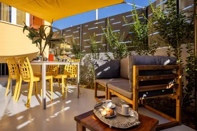 a patio with a table and chairs and a couch at La casetta di Levante in Terrasini