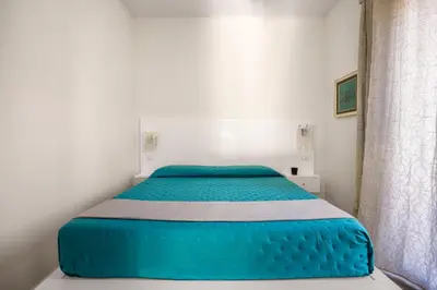 a bedroom with a blue bed in a white room at La casetta di Levante in Terrasini