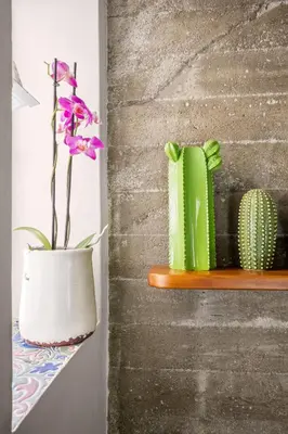 a white vase with a flower in it on a shelf at La casetta di Levante in Terrasini