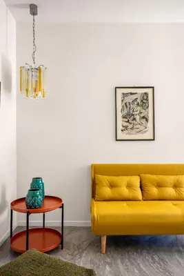 a living room with a yellow couch and a table at La casetta di Levante in Terrasini