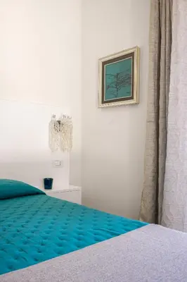 a bedroom with a bed and a picture on the wall at La casetta di Levante in Terrasini