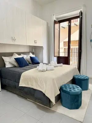 a bedroom with a large bed with blue accents at Tra i Vicoli del Capo in Palermo