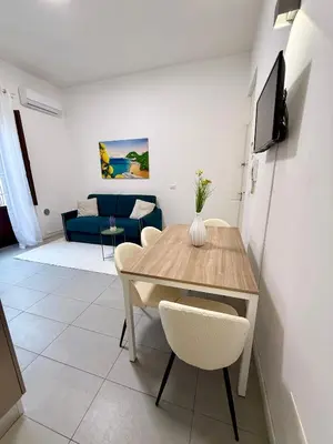 a dining room with a table and a couch at Tra i Vicoli del Capo in Palermo