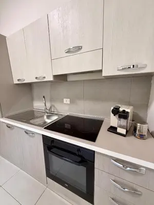 a kitchen with a sink and white cabinets at Tra i Vicoli del Capo in Palermo