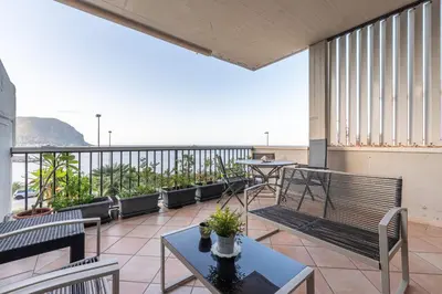 a balcony with chairs and tables and a view of the ocean at Casa Azzurra vista mare all'Addaura by Wonderful Italy in Palermo