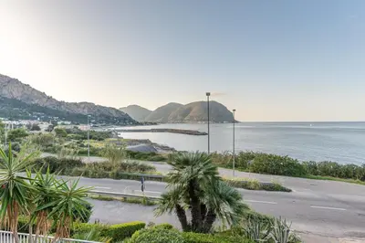 a view of a beach with mountains and the ocean at Casa Azzurra vista mare all'Addaura by Wonderful Italy in Palermo