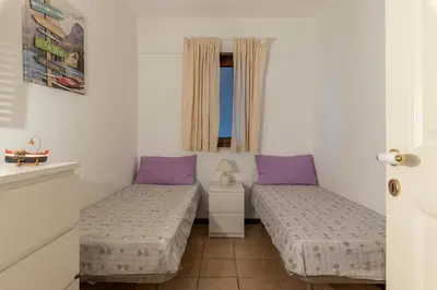 two beds in a small room with purple pillows at Casa Azzurra vista mare all'Addaura by Wonderful Italy in Palermo