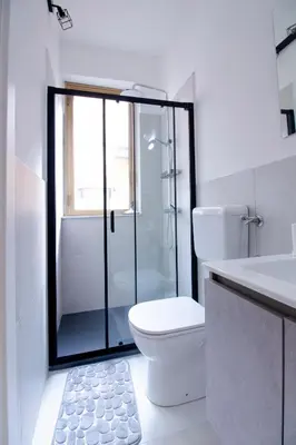 a bathroom with a toilet and a glass shower at I tre Mori in Monreale
