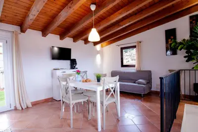 a kitchen and living room with a white table and chairs at I tre Mori in Monreale