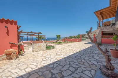 a stone walkway next to a building with the ocean in the background at A Casa di Amy in Macari