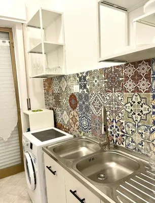 a small kitchen with a sink and tiles on the wall at Casa Mondello Sea Life in Palermo
