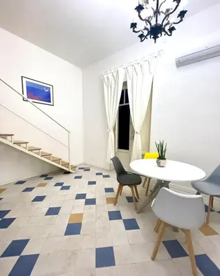 a room with a table and chairs and a staircase at Casa Mondello Sea Life in Palermo