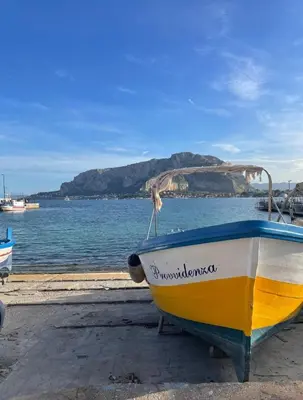 a yellow and blue boat sitting on the beach at Casa Mondello Sea Life in Palermo