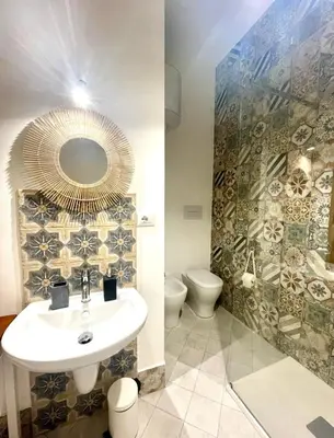 a bathroom with a sink and a toilet and a mirror at Casa Mondello Sea Life in Palermo
