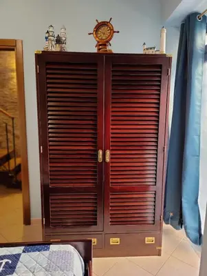 a wooden cabinet with a clock on top of it at La Muciara - Best Hospitality in Palermo