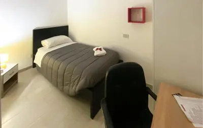 a small bedroom with a bed and a chair at Stunning Apartment In Palermo With Wifi in Palermo