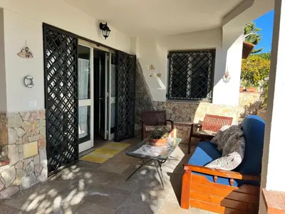 a patio with a blue couch and a table at Casa sul mare Lalu a 20 kl da Palermo e 30 da Cefalu tre camere 9 posti in Santa Flavia