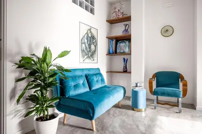 a living room with a blue couch and two chairs at Blu House in Terrasini