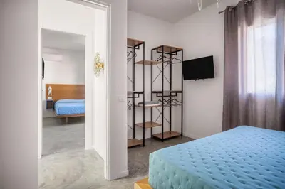 a bedroom with a blue bed and a room with a bed at Blu House in Terrasini