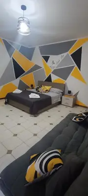 a room with two beds and a geometric wall at Casa Sarina in Monreale