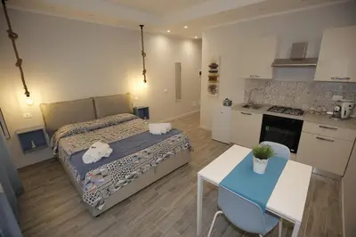 a small bedroom with a bed and a kitchen at Belle Arti in Palermo