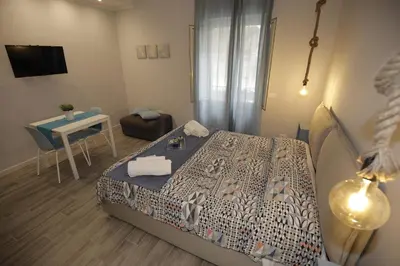 a bedroom with a bed and a table and a chair at Belle Arti in Palermo