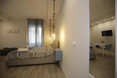 a bedroom with a bed and a room with a table at Belle Arti in Palermo