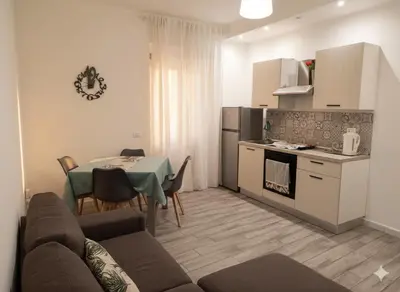 a living room with a couch and a table and a kitchen at Belle Arti in Palermo
