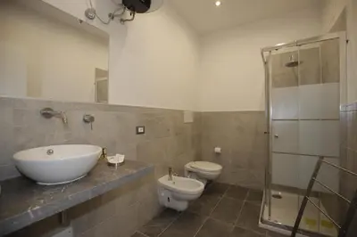 a bathroom with a sink and a toilet and a mirror at Belle Arti in Palermo