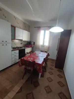 a kitchen with a table and chairs and a kitchen with white cabinets at Casa vacanze balestrate in Balestrate