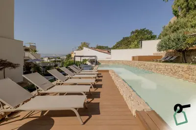 a row of chaise lounge chairs next to a swimming pool at HOTIDAY Mondello Beach in Mondello