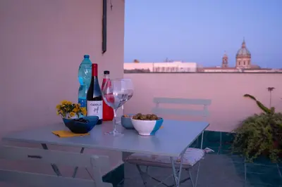 a table with two glasses and a bottle of wine at In Torre Palazzo Orioles in Palermo