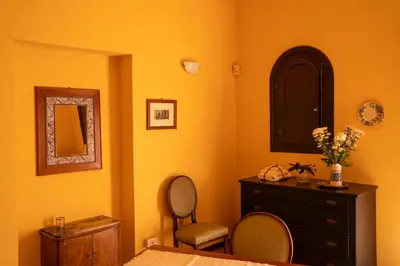 a room with two chairs and a dresser and a mirror at In Torre Palazzo Orioles in Palermo