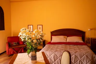 a bedroom with a bed and a vase of flowers on a table at In Torre Palazzo Orioles in Palermo