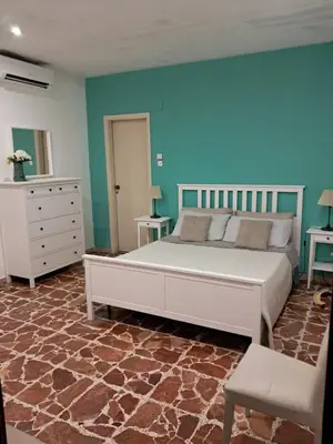 a bedroom with a large white bed and blue walls at Casa Kennedy in Capaci