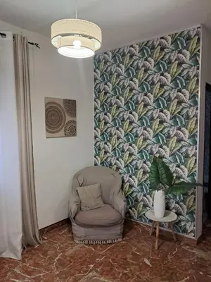 a living room with a chair and a wall mural at Casa Kennedy in Capaci
