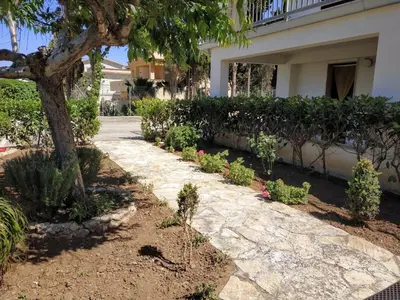 a stone walkway in front of a house with plants at Casa vacanze mare Rosa in Castellammare del Golfo