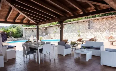 a patio with a table and chairs and a pool at Villa Aversa in Castellammare del Golfo