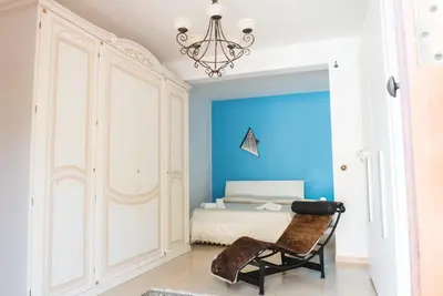 a bedroom with a bed with a blue wall at Villa Aversa in Castellammare del Golfo