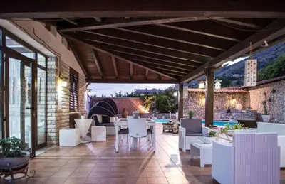 a patio with white chairs and tables in a building at Villa Aversa in Castellammare del Golfo