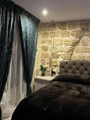 a bedroom with a bed and a stone wall at Ai Chiavettieri Suite in Palermo