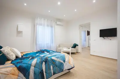 a bedroom with a bed and a flat screen tv at Dominic Luxury House - a 2 passi dalla cattedrale in Palermo