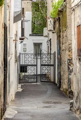 an alley with a gate in a white building at Sicily Bed' House in Palermo