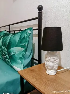 a lamp sitting on a table next to a bed at Sicily Bed' House in Palermo