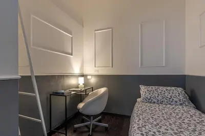 a bedroom with a bed and a desk and a ladder at La Terrazza sul Massimo in Palermo
