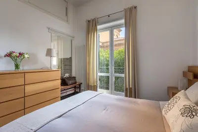 a bedroom with a bed and a dresser and a window at La Terrazza sul Massimo in Palermo