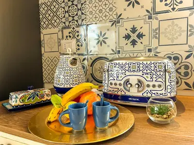 a table with a plate of fruit and a toaster at B&B Il Mare di Terrasini in Terrasini